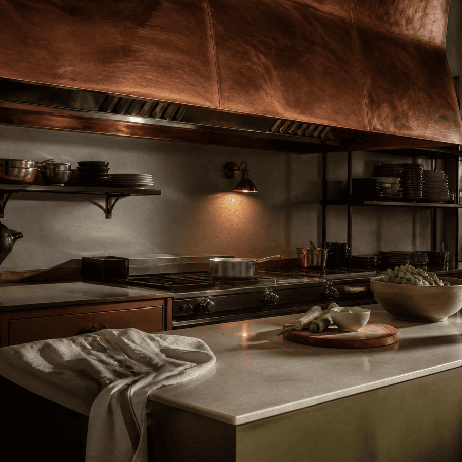 Brushed copper restaurant hood above an empty cook line